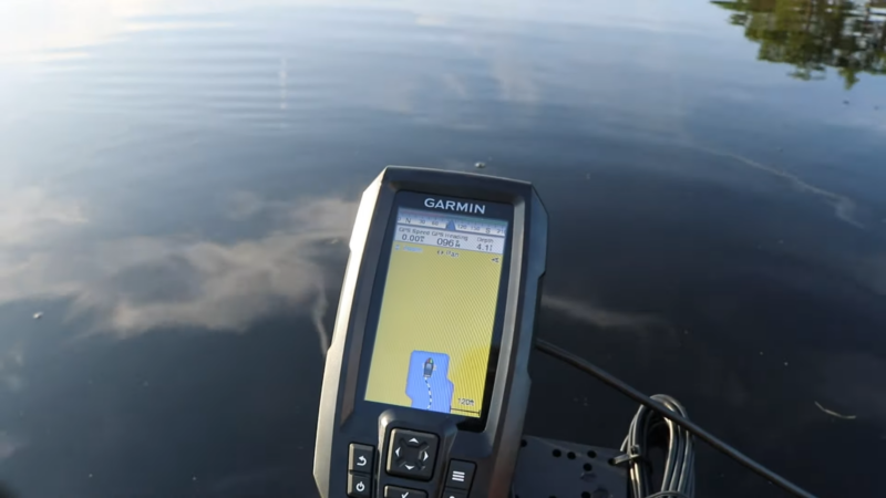 Garmin Fish Finder Displaying Gps and Depth Information on A Boat Over Still Water