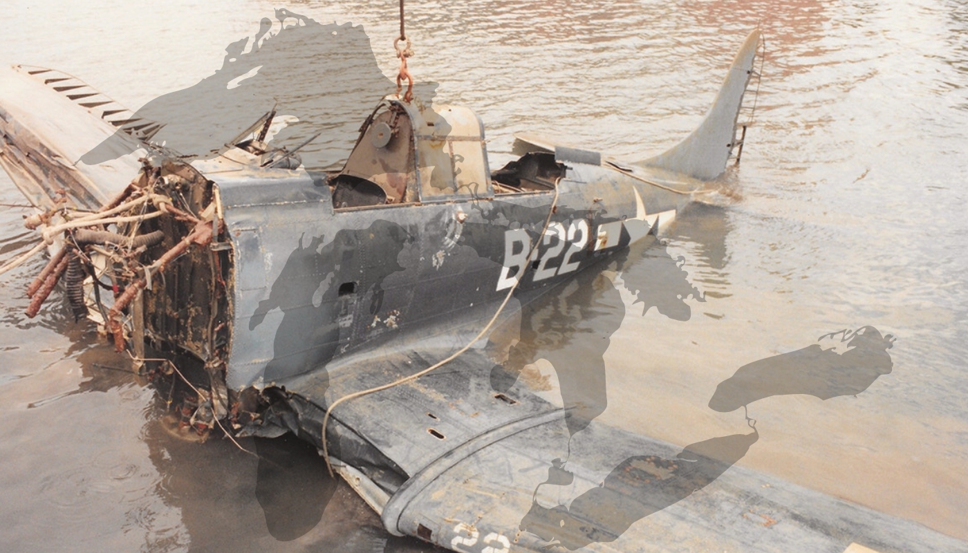 Partially submerged Douglas SBD-4 Dauntless aircraft wreck being lifted from the water