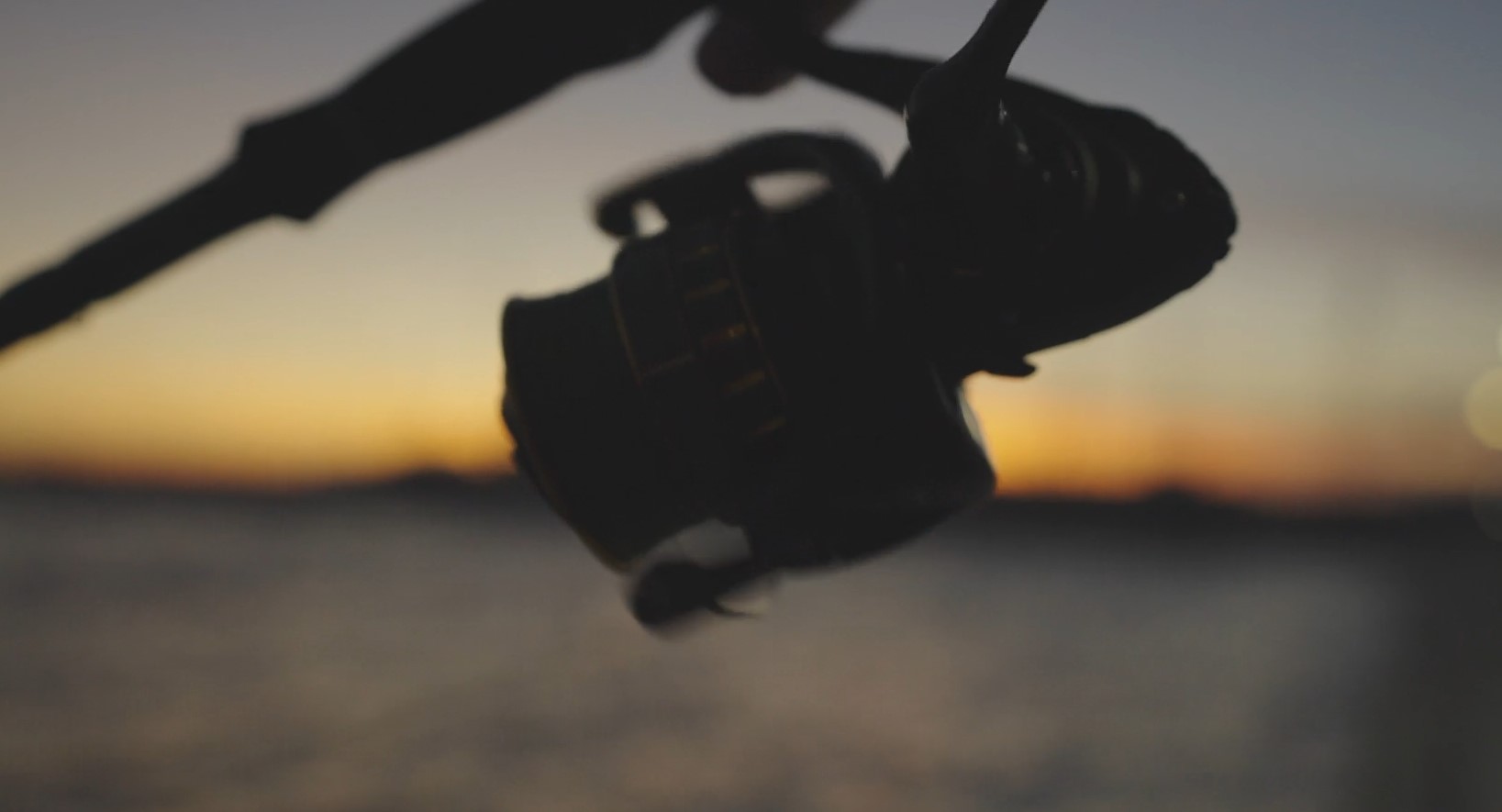 Silhouette of a fishing reel on a fiery sunset